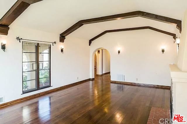 empty room with dark hardwood / wood-style floors and lofted ceiling with beams