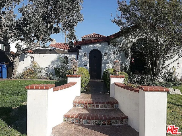 mediterranean / spanish-style house featuring a front lawn