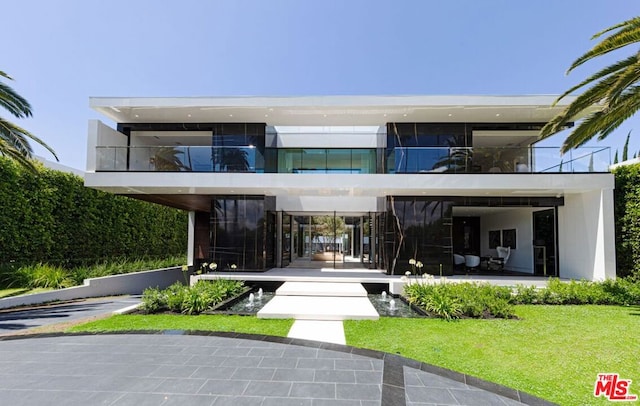 rear view of property with a lawn and a patio area