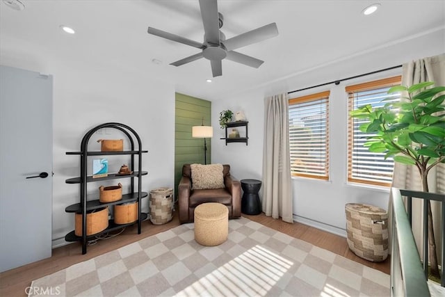 sitting room with light wood-type flooring and ceiling fan