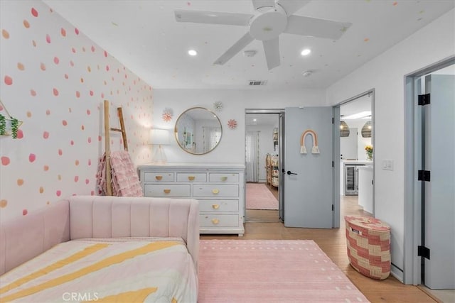 bedroom featuring light hardwood / wood-style floors, ceiling fan, and wine cooler