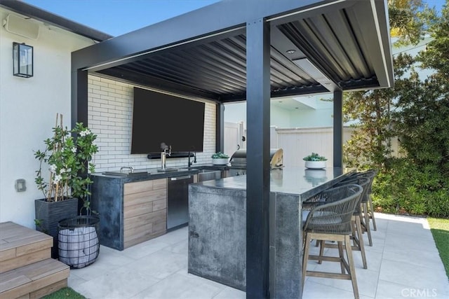 view of patio with exterior kitchen and a bar