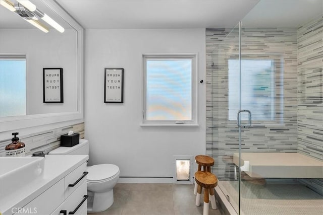 bathroom featuring toilet, walk in shower, a wealth of natural light, and vanity