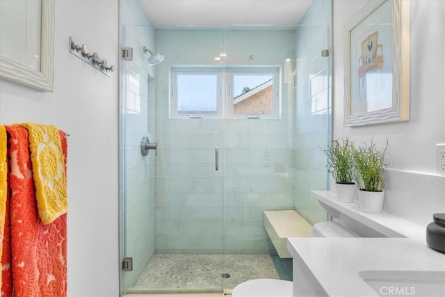 bathroom with vanity, toilet, and a shower with door