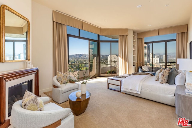 carpeted bedroom with a mountain view, multiple windows, and access to outside