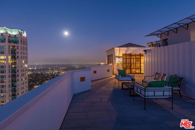 patio terrace at dusk with a balcony and outdoor lounge area