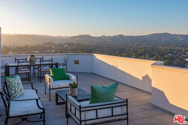 patio terrace at dusk with an outdoor living space and a mountain view