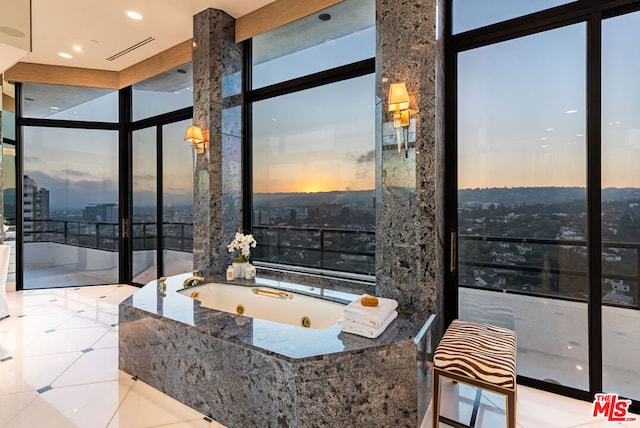 bathroom featuring a wall of windows, a relaxing tiled tub, and tile patterned floors