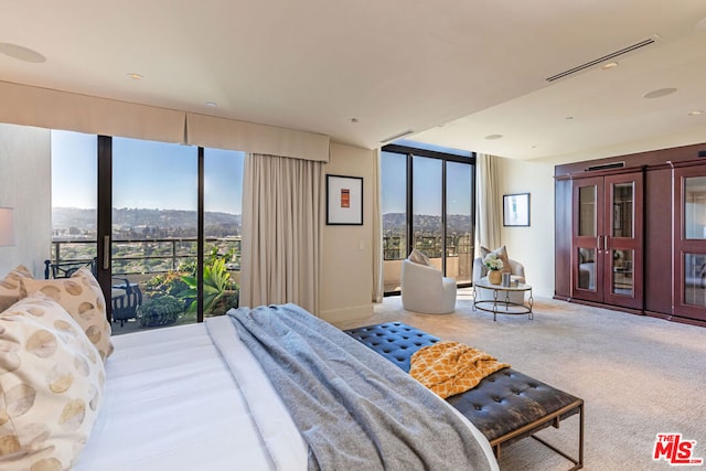 carpeted bedroom featuring a mountain view, expansive windows, and access to outside