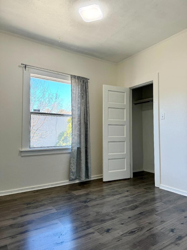 unfurnished bedroom featuring ornamental molding, dark hardwood / wood-style floors, and a textured ceiling