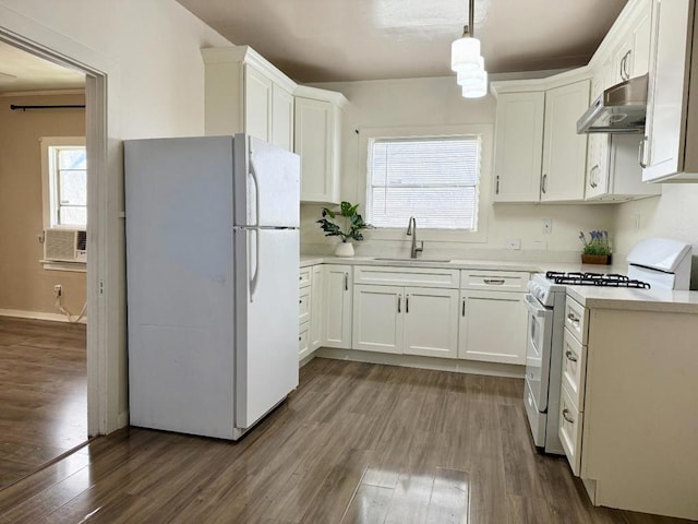 kitchen with sink, white cabinetry, hanging light fixtures, dark hardwood / wood-style floors, and white appliances