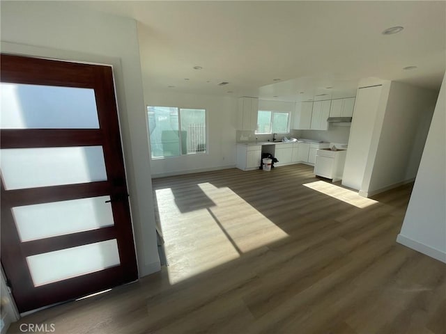 unfurnished living room featuring sink and dark hardwood / wood-style floors