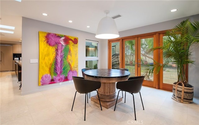 dining space with french doors and a skylight