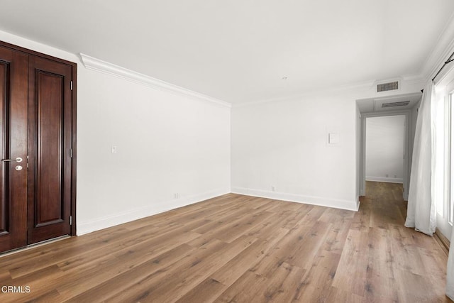 unfurnished room with light hardwood / wood-style flooring and crown molding