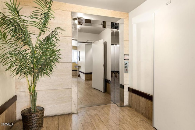 hall featuring elevator and light wood-type flooring