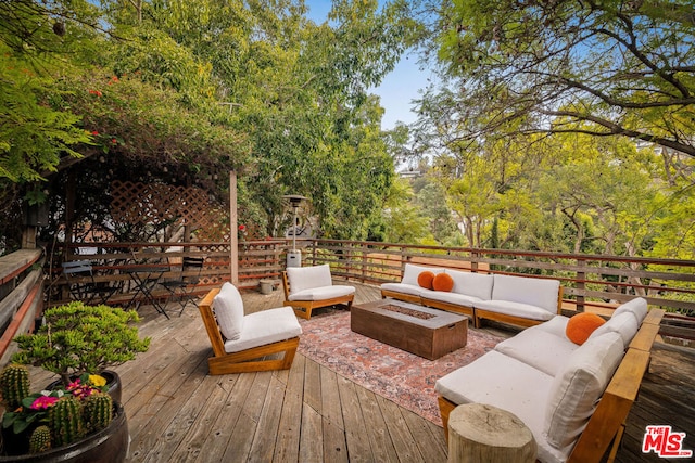 wooden terrace featuring an outdoor living space with a fire pit