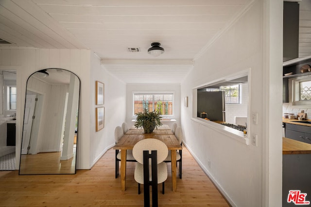 dining room featuring crown molding and light hardwood / wood-style floors