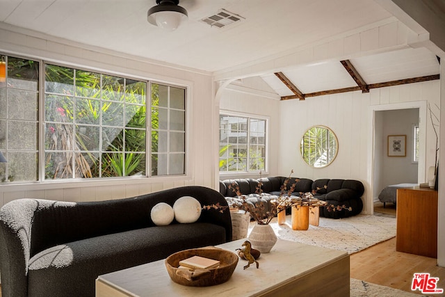 living room with lofted ceiling with beams and light wood-type flooring