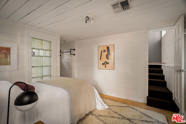 bedroom with wood ceiling, wooden walls, and wood-type flooring