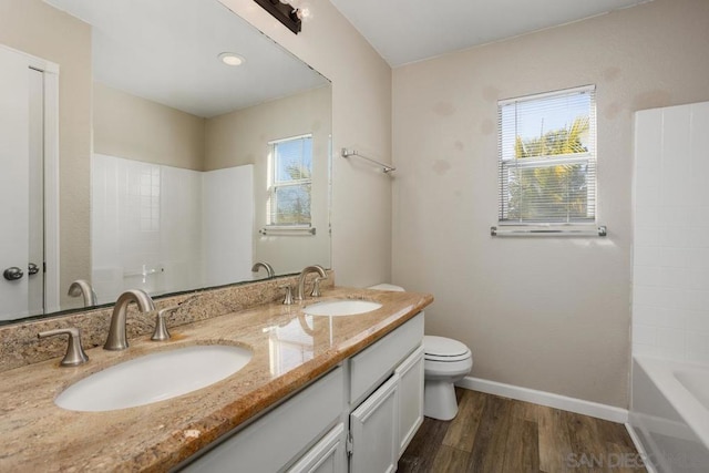 bathroom featuring hardwood / wood-style flooring, vanity, plenty of natural light, and toilet