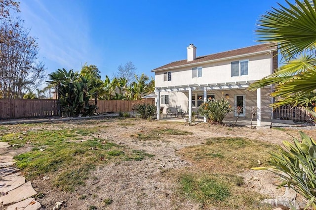 back of property with a pergola and a patio