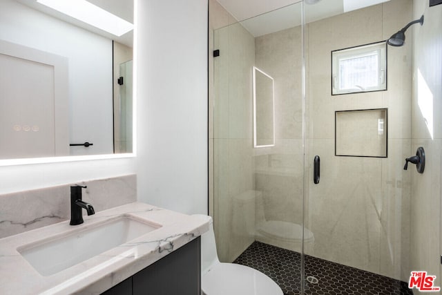 bathroom with toilet, walk in shower, and vanity