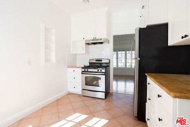 kitchen with white cabinets, stainless steel range with gas stovetop, and light tile patterned floors