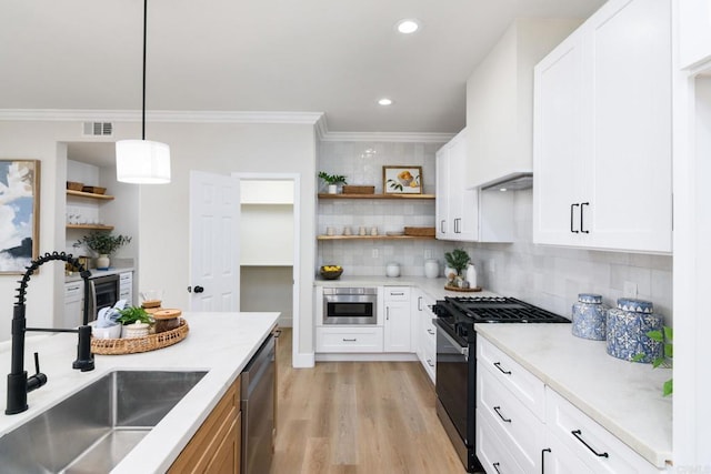 kitchen with sink, white cabinets, pendant lighting, and appliances with stainless steel finishes