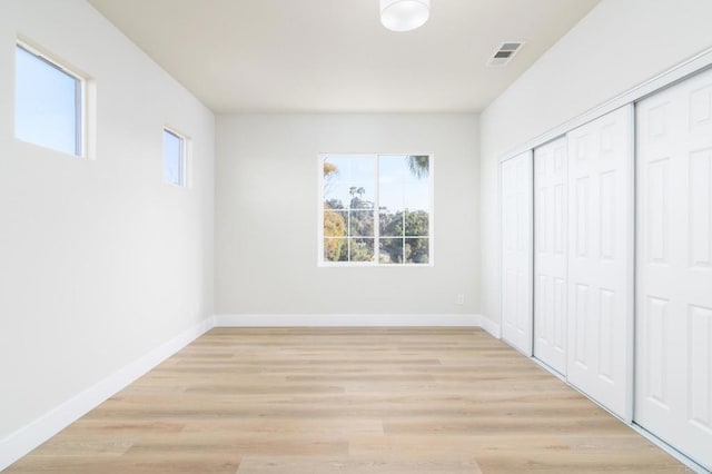 unfurnished bedroom featuring light hardwood / wood-style floors and a closet