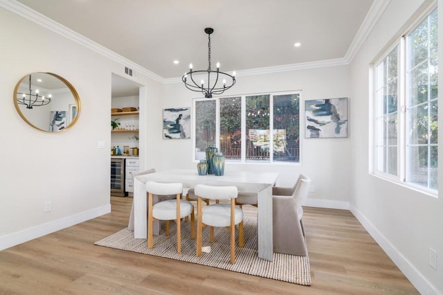 dining space featuring a notable chandelier, indoor bar, crown molding, light hardwood / wood-style flooring, and beverage cooler