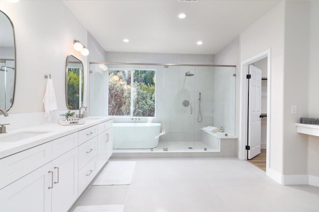 bathroom featuring vanity and independent shower and bath