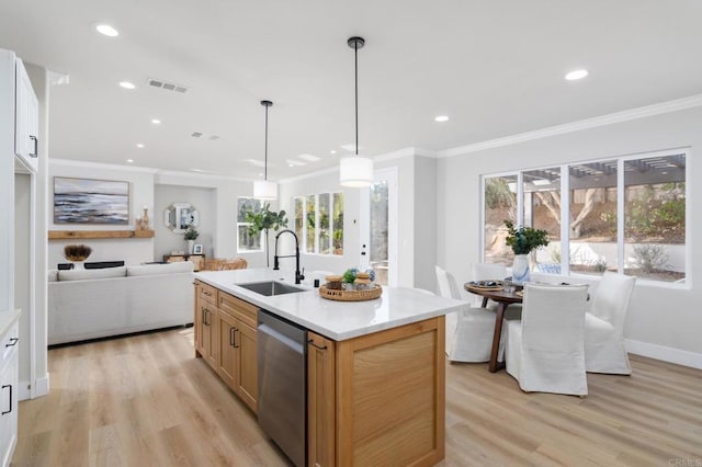 kitchen with stainless steel dishwasher, pendant lighting, sink, white cabinets, and an island with sink