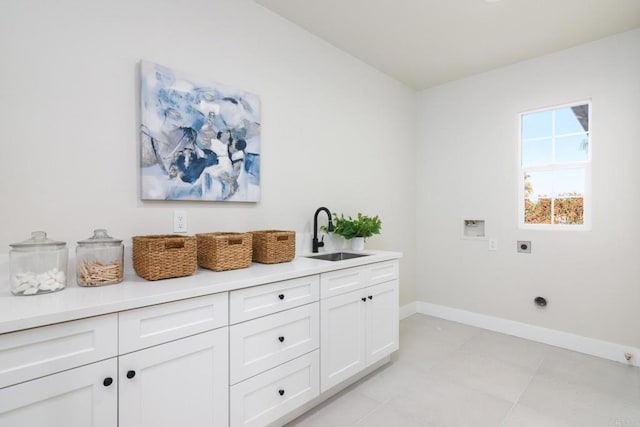 clothes washing area featuring sink, hookup for an electric dryer, cabinets, and washer hookup