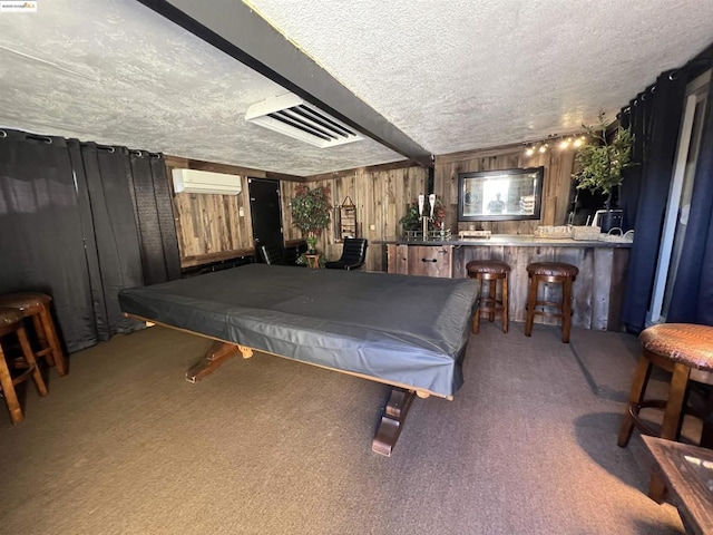 recreation room featuring wood walls, a wall mounted AC, a textured ceiling, and carpet floors