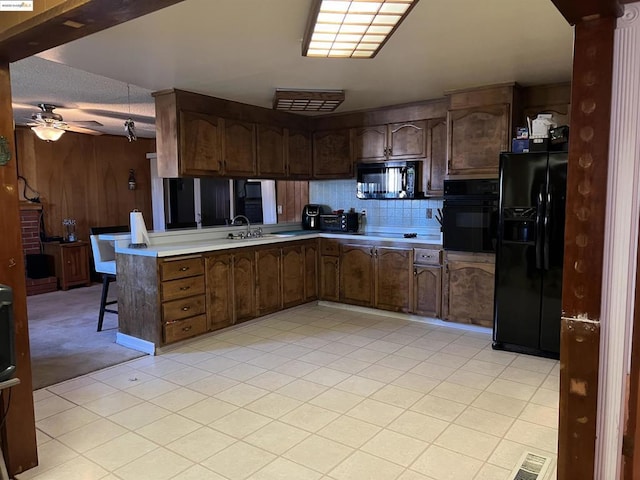 kitchen featuring kitchen peninsula, ceiling fan, sink, a textured ceiling, and black appliances