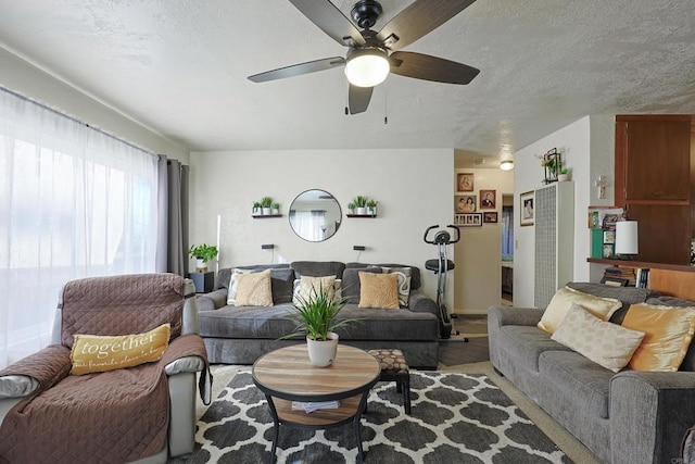 living room with a textured ceiling and ceiling fan