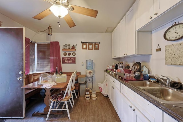 kitchen featuring dark wood-type flooring, sink, white cabinets, and ceiling fan