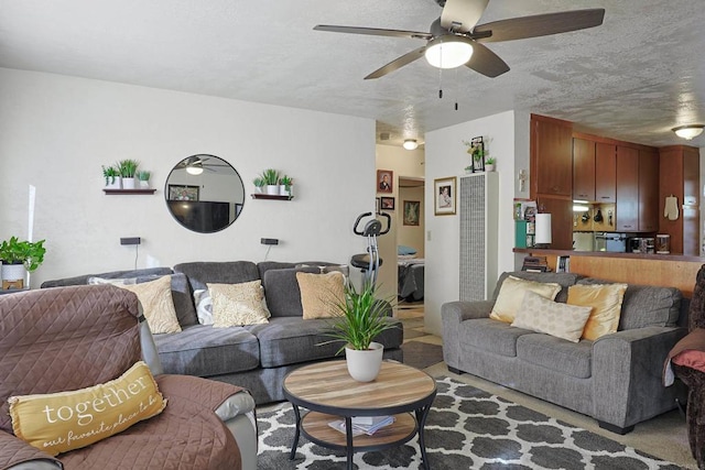 living room with a textured ceiling and ceiling fan