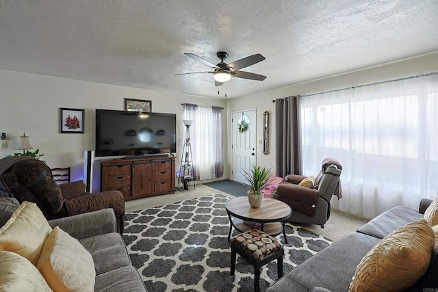 carpeted living room featuring ceiling fan, a textured ceiling, and a wealth of natural light