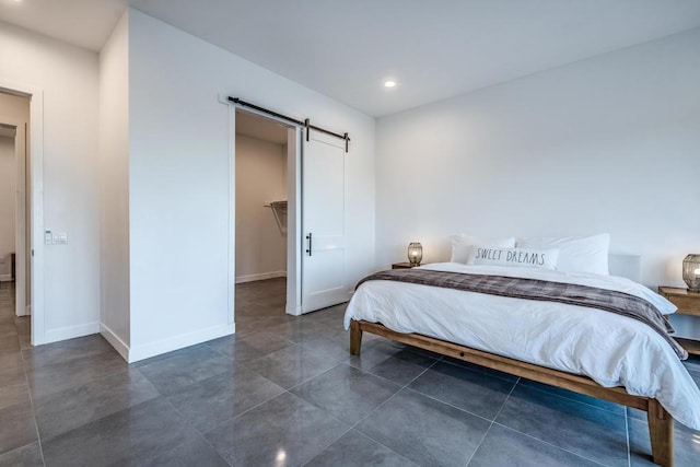 bedroom with a closet, a spacious closet, and a barn door