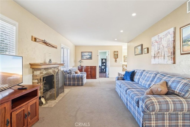 living room featuring light colored carpet and a stone fireplace