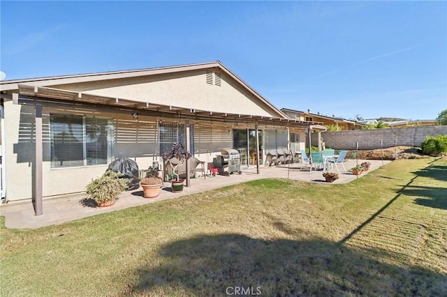 back of house with a yard and a patio area