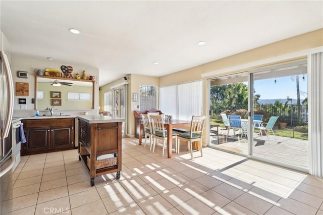 kitchen featuring light tile patterned flooring, range, kitchen peninsula, and sink