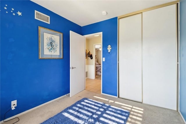 unfurnished bedroom featuring light carpet and a closet