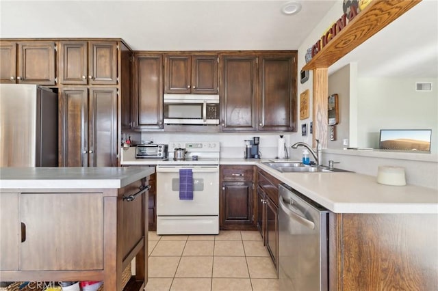 kitchen featuring sink, light tile patterned floors, and stainless steel appliances