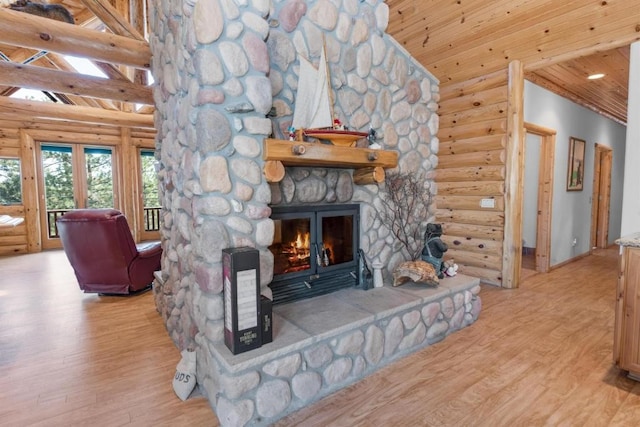 living room featuring a fireplace, log walls, wood finished floors, high vaulted ceiling, and wooden ceiling