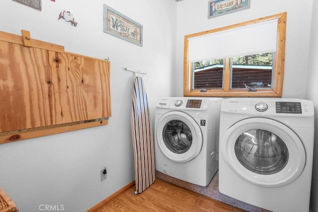 laundry room with light hardwood / wood-style flooring and washing machine and dryer