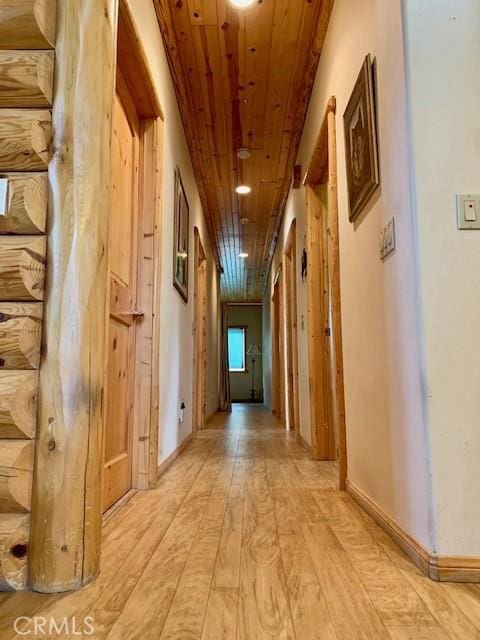 hall with wood ceiling, baseboards, and light wood finished floors