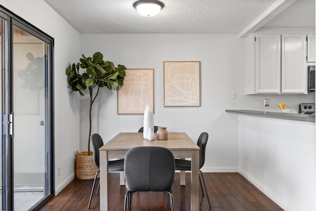 dining area featuring dark hardwood / wood-style flooring and a textured ceiling