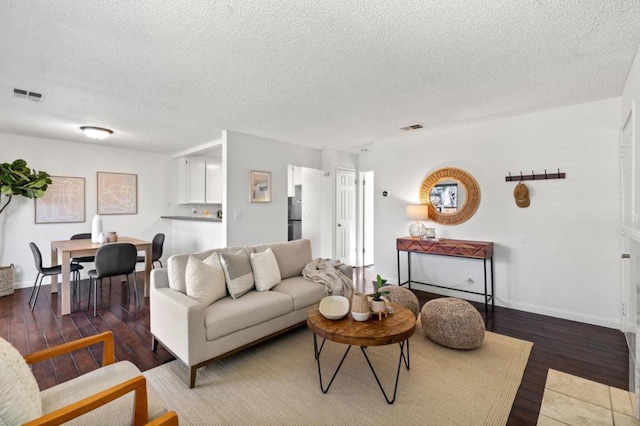 living room featuring dark hardwood / wood-style flooring and a textured ceiling